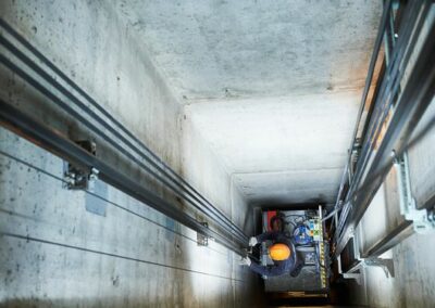 lift machinist repairing elevator in lift shaft